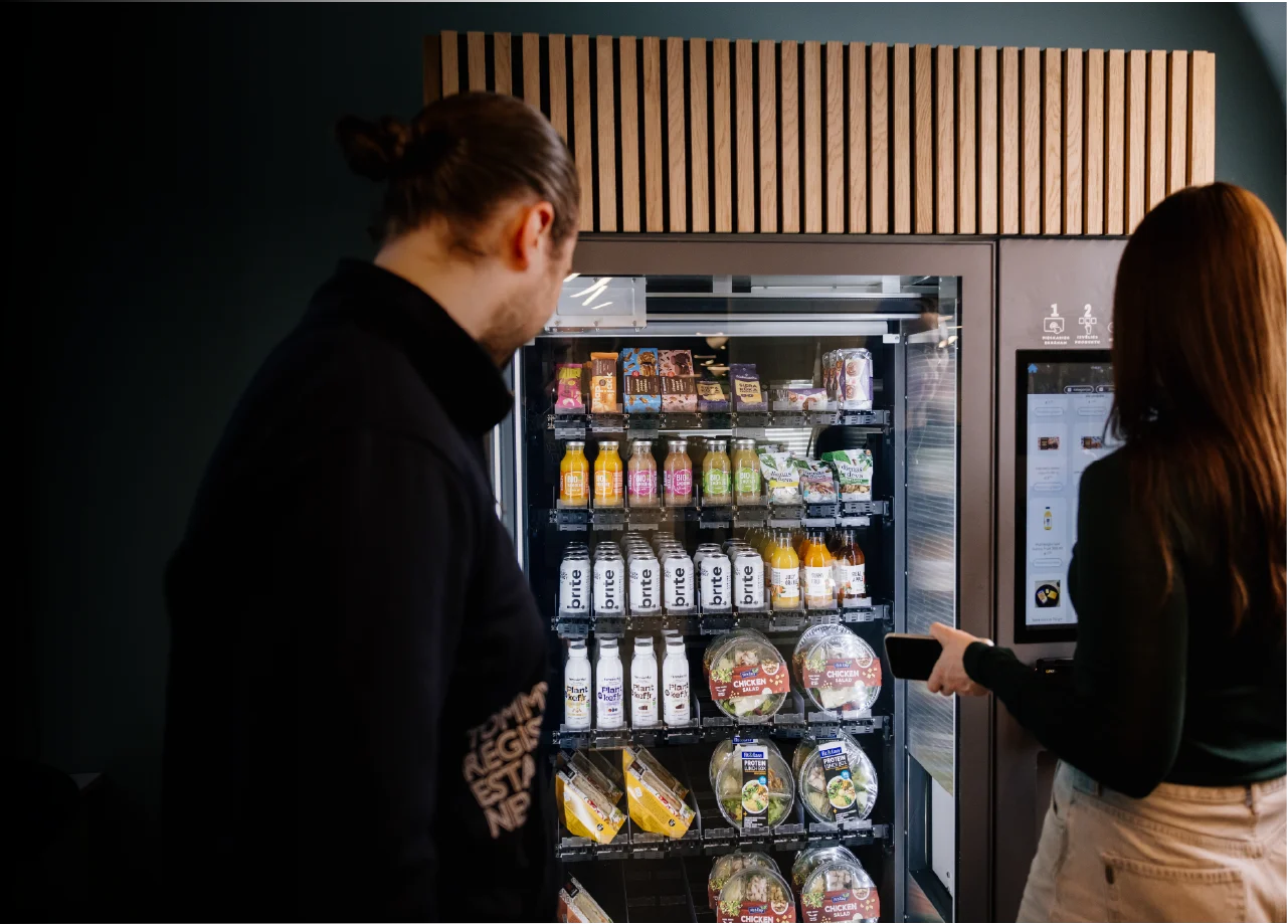 People standing around vending machine