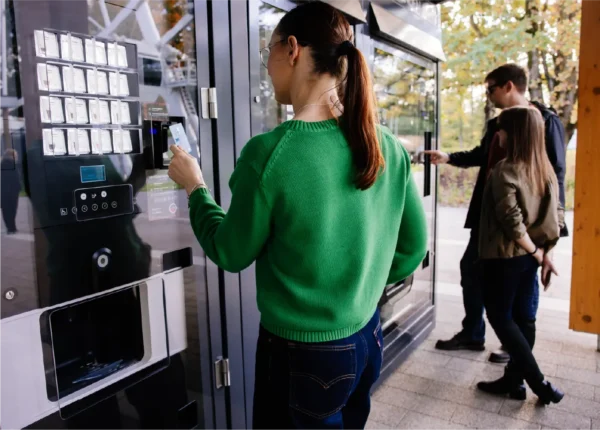 person paying with card at a vending machine